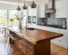 Modern luxury kitchen with a live edge suar wood waterfall island and sleek, minimalist white cabinets.