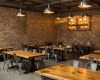 The authentic, rustic-industrial atmosphere of this luxury restaurant is created by bespoke live edge suar tables.