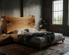 A handcrafted live edge suar wood bed creates a warm focal point in this modern, industrial-style luxury bedroom.