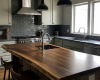 A luxury rustic-industrial kitchen's focal point is a thick, character-rich live edge island with a suar wood top.