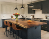 Luxury country-style kitchen featuring a large, solid oak island with a thick, straight-edged butcher-block top.