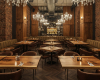 A luxury restaurant's atmosphere is defined by wood wall paneling, chandeliers, and custom live edge tables.