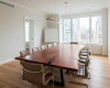 A masterpiece, bespoke boardroom table with a long, sweeping live edge curve and a dark, kintsugi-style repair.