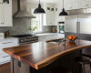 A luxury modern farmhouse kitchen's focus is a live edge island with a thick, rich walnut top and a prep sink.