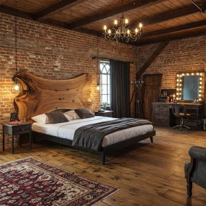 A luxury rustic-chic bedroom's focal point is a statement live edge bed with a unique, wing-shaped suar headboard.
