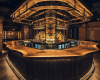 A masterpiece bar installation with a live edge suar wood top, mirrored by a unique, suspended wood canopy above.