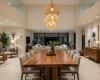 A 10-seater suar dining tabletop with a liquid, molten-flow live edge and a prominent central burl that anchors the grain.