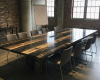 A 12-seater masterpiece conference tabletop made from petrified wood with a high-contrast striped pattern and a tech hub.