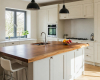 A luxury classic shaker kitchen's focus is a live edge island with a rich walnut top and an integrated prep sink.