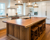 Bespoke live edge kitchen island with a thick, single-slab worktop, set within a luxurious modern farmhouse kitchen.