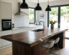 Bespoke live edge kitchen island with a thick, single-slab top and integrated sink in a luxury modern kitchen.
