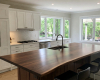 Bespoke kitchen island with a thick, single-slab suar worktop and integrated sink in a luxury white kitchen.