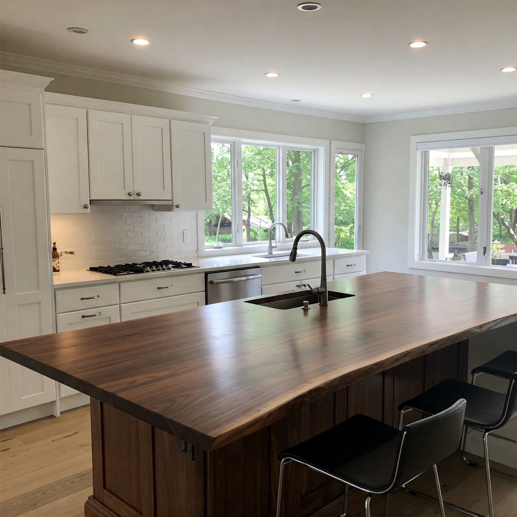 Bespoke kitchen island with a thick, single-slab suar worktop and integrated sink in a luxury white kitchen.