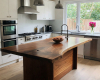 A luxury two-tone kitchen's centerpiece is a live edge island with a thick, rich suar top and an integrated sink.