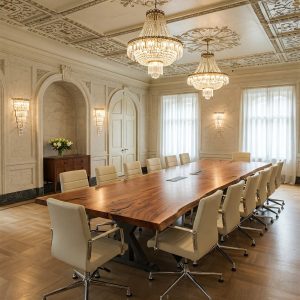 A unicorn-grade, 14-seater live edge boardroom tabletop of suar wood with two discreet technology integration ports.