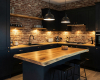 A handcrafted suar wood live edge island is the highlight of this industrial kitchen with exposed brick walls.