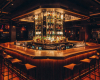 A luxury modern venue's centerpiece is a unique, hexagonal island bar with a subtle live edge suar wood top.