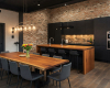 Luxury modern-industrial kitchen with black cabinets, a waterfall island, and a beautiful live edge dining table.